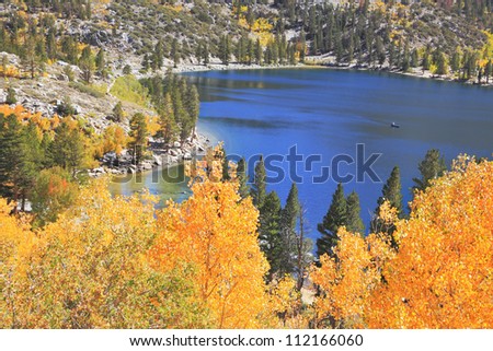 Magic beauty the dark blue lake in Yosemiti\'s National park. Gold crowns create an unforgettable picture.
