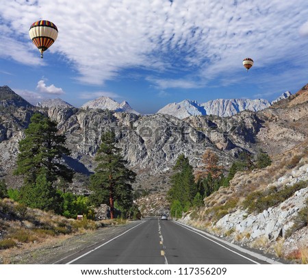 Huge balloons with the passenger basket flying over the magnificent American roads in the mountains