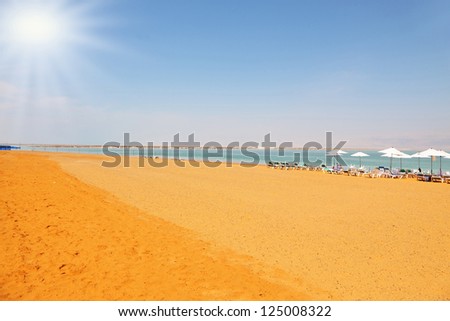 Middle-aged woman on the beach luxury hotel on the Dead Sea in Israel. Sunny spring day