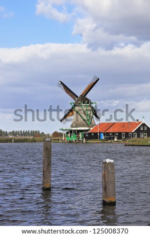 The windmills and economic constructions with triangular roofs on the bank of the channel