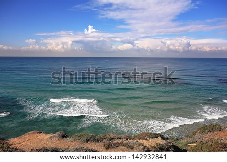 The Mediterranean coast. Azure waves and spectacular bizarre clouds