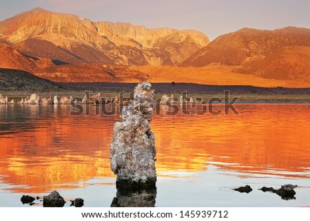 Orange sunset. The magic of Mono Lake. Outliers - calcareous tufa formation  on the smooth water of the lake