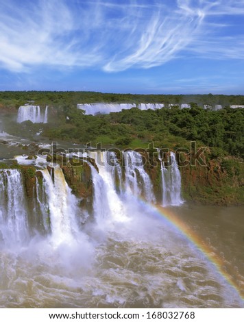 The most famous waterfalls in the world - Iguazu. Magnificent rainbow is above the thundering water jets. The Brazilian side of the falls