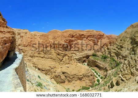 The road leading to the temple. The monastery of St. George Cozeba. The building of the monastery was built on the wall of the gorge of Wadi Kelt near Jerusalem