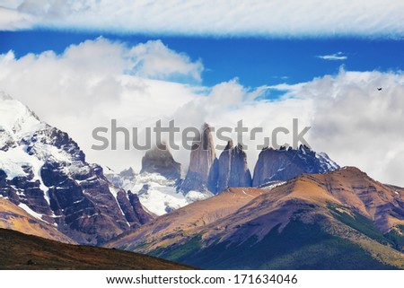 The primitive harmony of the national park Torres del Paine. Three of the famous rocks surrounded by picturesque clouds