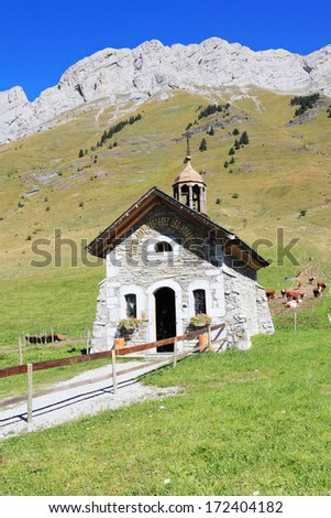 France, Haute Savoie. Adorable little chapel on the lawn in the mountains. Sunny spring day