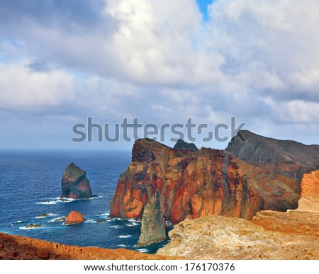 It is red and orange rocks coolly grow from foamy waves of the Atlantic Ocean. Easternmost tip of the island of Madeira