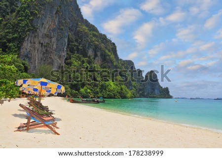 Wonderful vacation in the southern seas. Colorful beach umbrellas and sun beds for a rest on a sandy beach near the sea