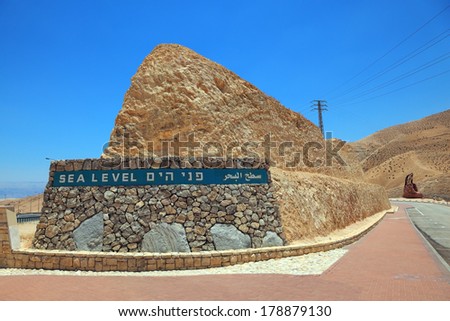Highway built in the valley of the Dead Sea in Israel. On the side of a highway sign \