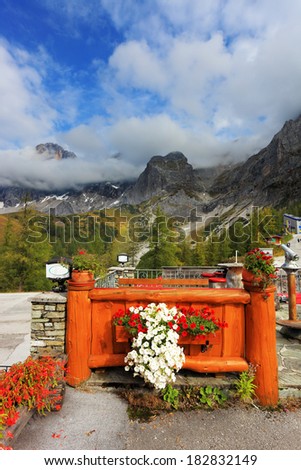 Large tourist center in the majestic Austrian Alps. Fence cozy cafe is decorated with flowers