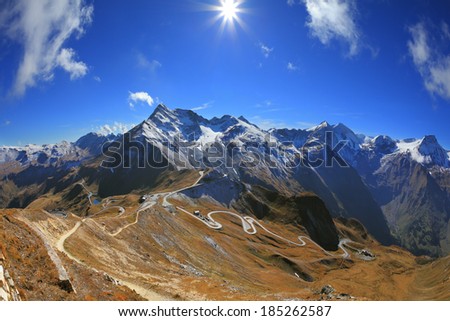 The picture was taken Fisheye lens. Austrian Alps. Excursion to the picturesque panoramic way Grossgloknershtrasse. Sunny day in early autumn. Great highway winds between hillsides yellowed