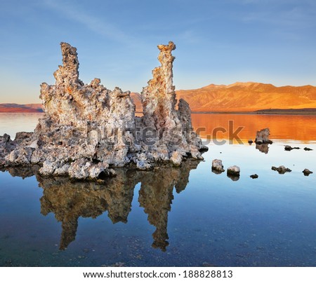 The magic of Mono Lake. Outliers - bizarre limestone formations reflected in the smooth water. Orange sunset