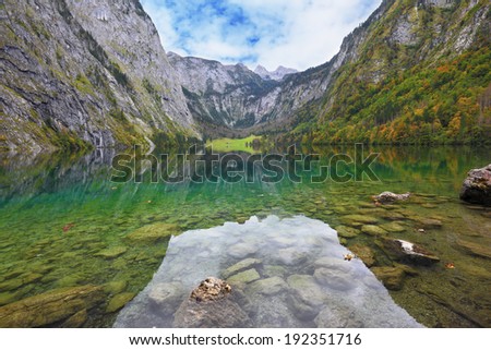 Fabulously beautiful lake Koenigssee. Mountainous lakeside reflected in the smooth water of the lake, like the wings of a butterfly