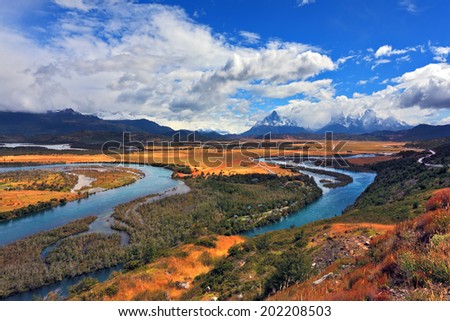 Glen Serrano. Meandering river bed of yellow autumn coast. Valley surrounded by snow-capped mountains