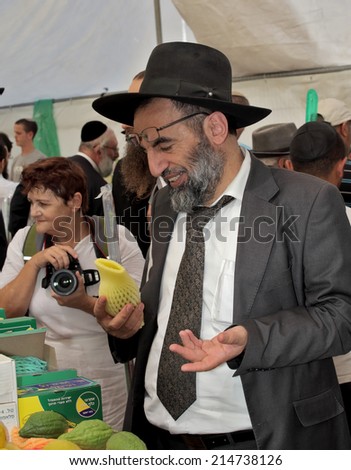 JERUSALEM, ISRAEL - SEPTEMBER 18, 2013: Religious Jew carefully chooses a ritual fruit.