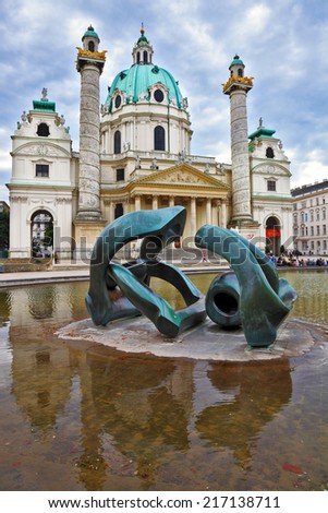 VIENNA, AUSTRIA - SEPTEMBER 26, 2013: Saint Karl Borromey\'s well-known church in Baroque style. On the square in front of church a big pond with a sculpture the Modernist style