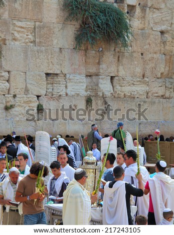JERUSALEM, ISRAEL - SEPTEMBER 20, 2013:The Western Wall of the Temple in Jerusalem. Many religious Jews in traditional robes tallit gathered for prayer. Morning Sukkot