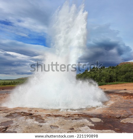 Iceland in the summer. Gushing geyser Strokkur. High column of hot water and steam from the crater of the geyser.