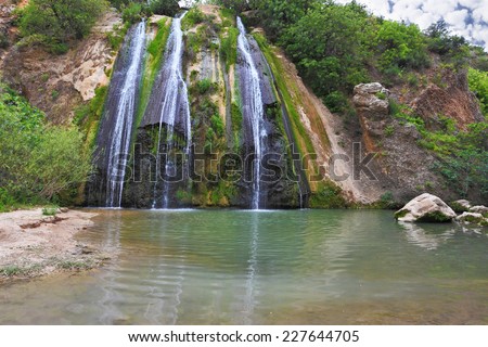 The original three-jet Falls on the border of Israel. Three parallel streams of water running down the steep slope and fall in oval pool