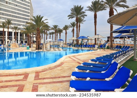 DEAD SEA, ISRAEL - DECEMBER 30, 2011: Winter in the Dead Sea. The picturesque pool and a comfortable high-rise hotel