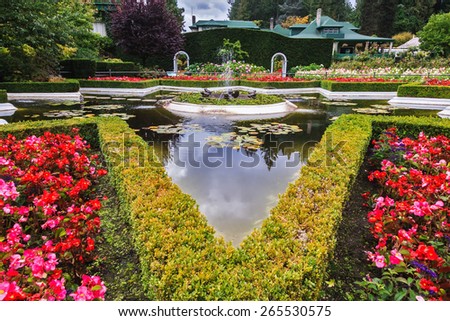 Exquisite fountain among the flower beds. Delightful landscaped and floral park Butchart Gardens on Vancouver Island