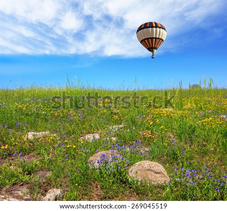 In a clear sky flying big colorful balloon. Flowering Golan Heights in a beautiful sunny day