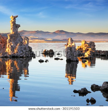 Yosemite National Park, USA. Outliers -  bizarre calcareous tufa formation  reflected in the mirrored surface of the water. The picturesque sunset at Mono Lake