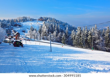 Winter mountain sports resort. Christmas in the forest.  Rolled ski trail glitters in sunny December day