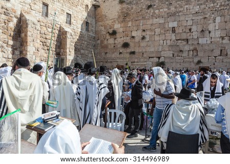 JERUSALEM, ISRAEL - OCTOBER 12, 2014:  Huge crowd of faithful Jews wearing white prayer shawls and black long-skirted coats. Morning Sukkot