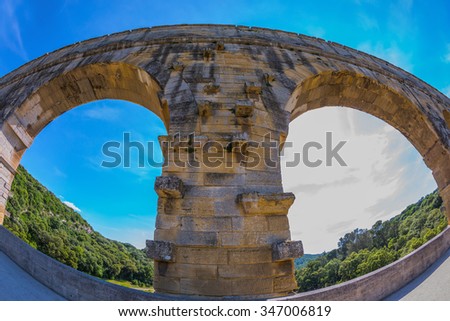 Part of the bridge. One bridge span is photographed lens Fisheye. Three-tiered aqueduct Pont du Gard - the highest in Europe. Provence, spring sunny day