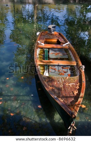 Canal and boat, covered with autumn leaves, a bright sunny noon
