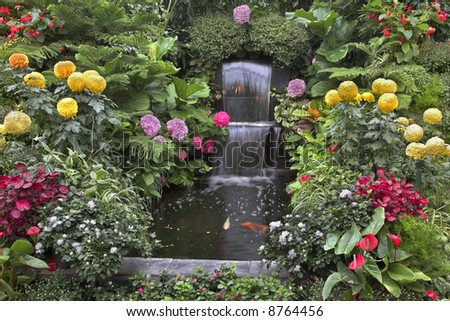 Gold small fishes and magnificent flower beds in a two-cascade falls in well-known Butchart Gardens