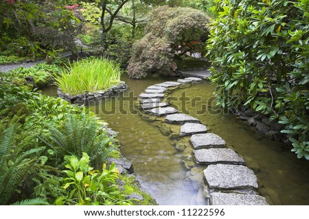 A footpath from stones laid with brick through a fine pond in Japanese garden