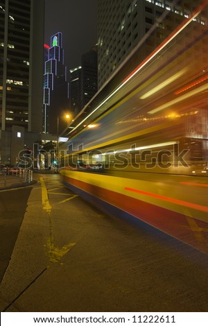 Night bus lit by advertisement lights on Hong-Kong street