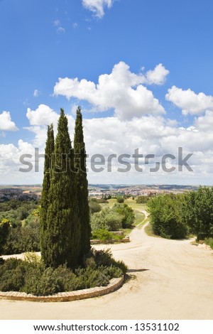 Rural hotel, twisting narrow road land cypresses in vicinities of ancient city Toledo in Spain