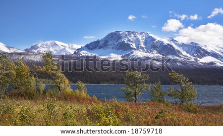 Cold autumn wind above deep lake with dark blue water