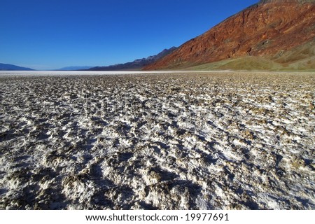 A dry waterless clay surface and mountains in the distance