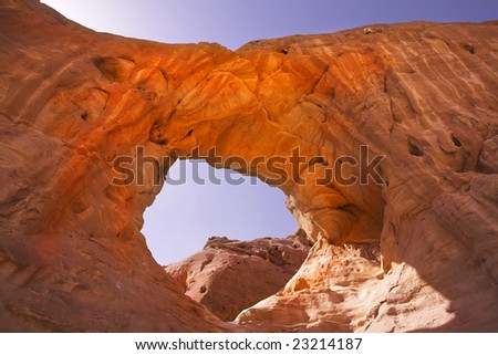 Natural picturesque erosive arch in hills from red sandstone