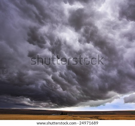 Enormous storm cloud above an autumn field