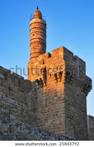 The ancient walls surrounding Old city in Jerusalem and the Tower of David, shined by the sun