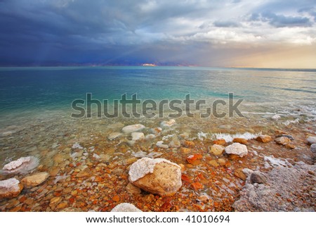 Coast of the Dead Sea in Israel in a spring thunder-storm. The coastal stones covered by salt