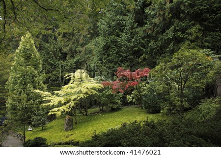 Small charming glade on slope of hill in well-groomed park
