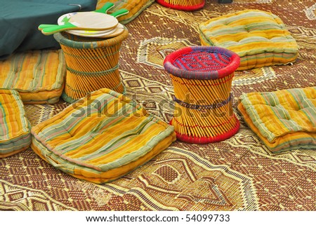 Utensils in ancient authentic bedouin tent - carpets, pillows and padded stools