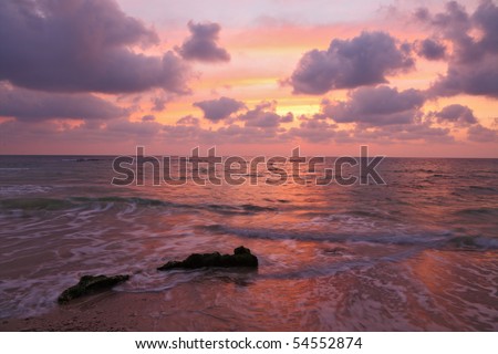 Enchanting sunset on Mediterranean sea. Pink clouds and reflections on the water