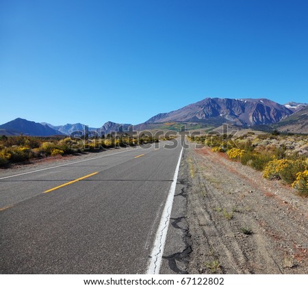 The road goes into the distance. Pride of the nation - a great American road goes through the beautiful desert to the distant mountains
