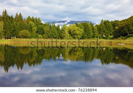 Cloudy sky reflected in water, a small lake in the mountains of northern Italy.