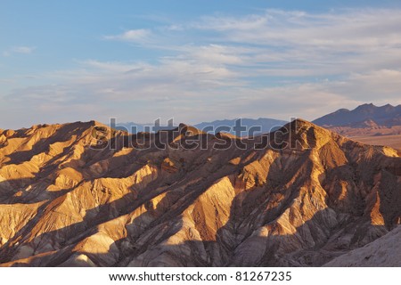 The well-known site of Death Valley in California - the Zabriski-point. Picturesque hills of pink, yellow and chocolate shades on a sunset