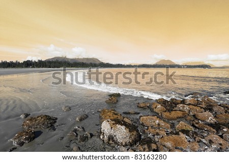 Vancouver Island, sunset. On the Pacific beach begins tide, wet sand, and puddles