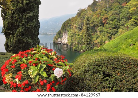 Magnificent park at the Italian villa-museum Balbyanello. Beautiful flower bed. Lake Como in the misty haze