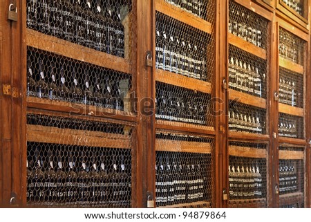 Wooden shelves with bottles of wine. Storage space for an expensive aged wines - Madeira.